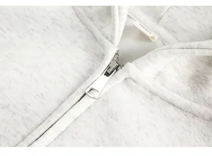 Detailed view of grey heather zip-up hoodie featuring smooth metal zipper and soft fabric.