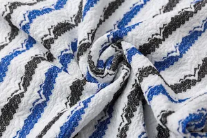Gedetailleerd overzicht van gebreide gestreepte casual overhemdstof met blauw-zwarte zigzag.
