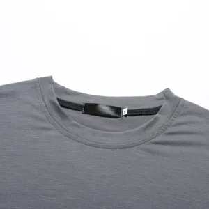 Men's solid color crew neck t-shirt collar detail view showing fine fabric texture and tag.
