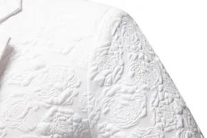 Close-up detail of mens white suit jacket with elegant embossed rose floral jacquard fabric.