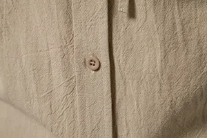 Close-up van heren casual linnen shirt knoopsgat en knop detail, getextureerde stof.