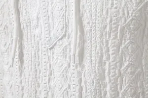 Close-up of white jacquard men shirt fabric, featuring breathable texture and drawstrings.