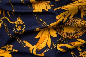 Detailansicht des Hemdstoffs mit luxuriösem goldenem Barockketten- und Blattdruck.