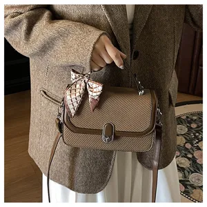 Detailed close-up view of stylish women's woven texture shoulder bag with chic scarf accessory.