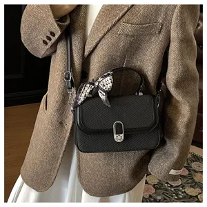 Black textured small square crossbody bag with handle and chic twilly scarf detail.