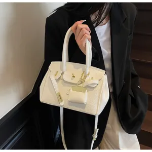 Vue détaillée d'un sac à main blanc pour femme, élégant sac à poignée avec fermoir en métal.