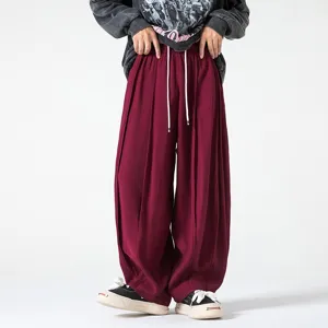 Detalle de pantalón ancho informal, estilo vintage burdeos baggy para hombres.