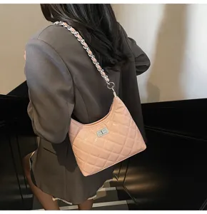 Détail de sac à bandoulière matelassé rose, élégant sac pour femme avec quincaillerie argentée.