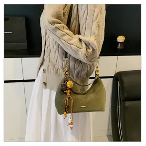 Green suede hobo bag detail shot, vintage underarm shoulder bag with wooden bead pendant.