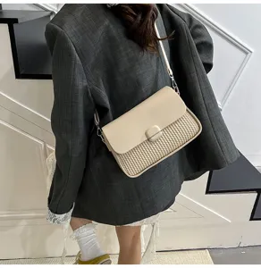 Close-up detail shot of the stylish beige shoulder bag showing its woven texture and flap design.