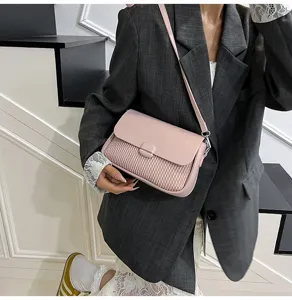 Detailed shot of a stylish light pink crossbody shoulder bag with a chic quilted panel.