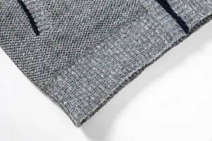Detailed view of men's knit cardigan hem showing grey textured fabric with contrast stripe.