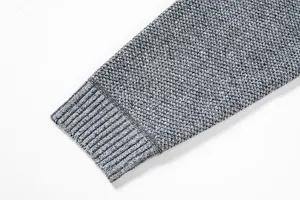 Detailed view of men's grey knit sweater sleeve cuff featuring textured fabric design.