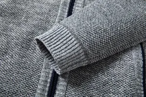 Detailed view of men's knitted cardigan cuff and textured fabric in classic grey melange.