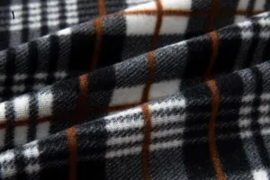 Close-up detail of mens fleece cardigan knitted fabric with classic black white brown plaid pattern.