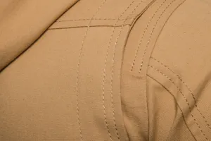 Detailaufnahme der robusten khaki Canvas Jacke mit präziser doppelter Steppnahtverarbeitung.