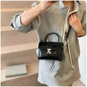 Black patent leather top handle crossbody bag for women, stylish commuter box shoulder bag.