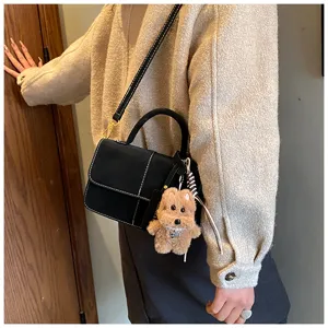 Chic minimalist black shoulder crossbody bag for women, trendy autumn winter handbag with plush charm.