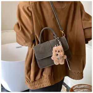 Detail view of the stylish dark grey shoulder bag with cute plush bear charm for daily wear.