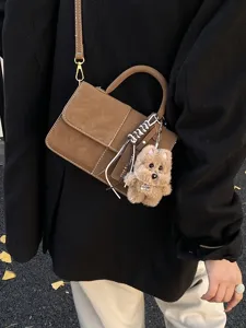 Stylish brown suede crossbody shoulder bag for women with cute plush puppy bag charm.