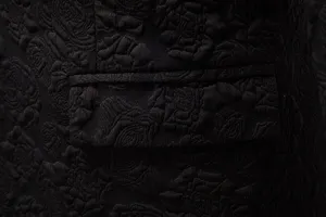 Close-up of black rose jacquard fabric showing men suit jacket pocket flap design.