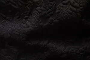 Men's suit fabric detail showing black rose jacquard texture for business formal wear.