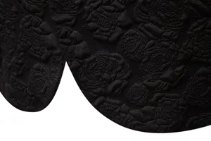 Detailed view of men's black floral jacquard suit hem, showing premium fabric texture.
