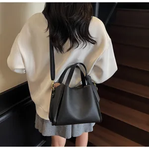 Detail view of a stylish black leather bucket bag, large capacity shoulder and crossbody design.