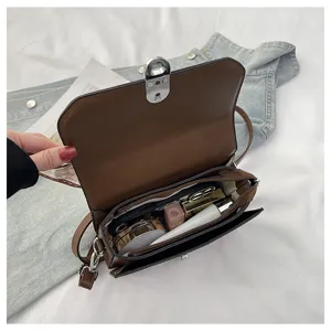 Detail shot of brown PU leather crossbody bag interior capacity, showcasing daily storage space.