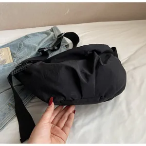 Detailed view of casual black nylon dumpling crossbody bag, lightweight wide strap commute bag.