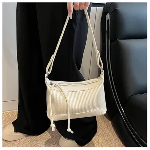 Detailed view of the pleated beige shoulder bag showcasing delicate texture, straps and rings.