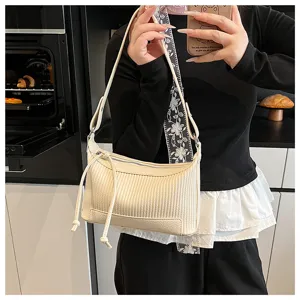 Detailed view of cream pleated shoulder bag with chic drawstring and soft PU leather design.
