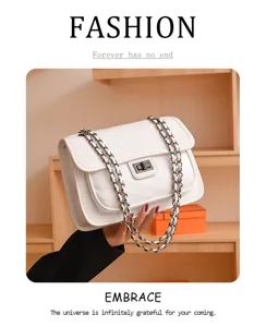 Close-up detail of a chic white quilted chain shoulder bag with chevron pattern and metal lock.