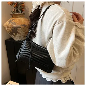 Detail view of black pleated shoulder bag, trendy underarm pillow bag with smooth metal zipper.