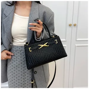 Detailed view of the black woven leather handbag, showcasing exquisite texture and gold hardware.
