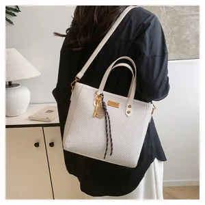 Large capacity white commuting tote bag with shoulder strap and metal tag detail for daily use.