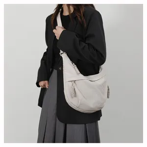 Minimalist grey crescent shoulder bag with unique braided zipper pullers for daily casual style.
