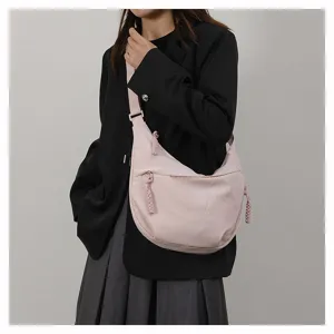 Women casual crossbody dumpling shoulder bag detail showing soft pink fabric and dual zippers.