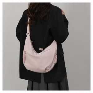 Detail view of the pink casual crossbody dumpling bag showing smooth zipper and braided pull.