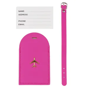 Set etichetta valigia in pelle rosa con logo aereo dorato, targhetta per bagaglio e cinturino.