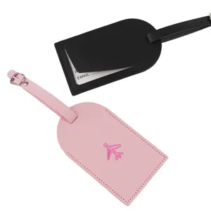 Detail shot of leather luggage tags in black and pink with embroidery airplane and info card slot.