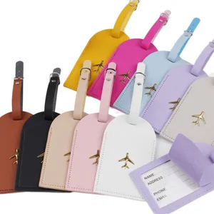 Set di etichette per bagagli in pelle colorata con ciondolo aereo dorato e porta carte.