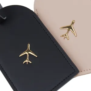 Dettaglio di etichetta per bagaglio, in pelle PU con dettaglio logo aereo metallico.