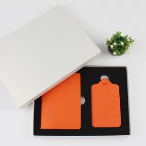 Nahaufnahme des leuchtend orangen Reisepasshalters und Kofferanhängers in der Geschenkbox.