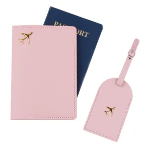 Set copripassaporto ed etichetta per valigia in ecopelle rosa con ciondolo aereo dorato.