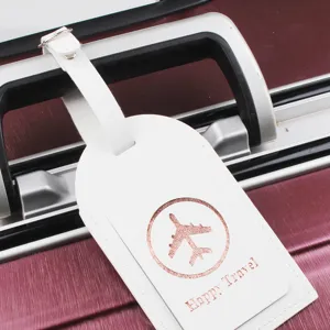 Etichetta per bagaglio in pelle PU bianca con icona aereo e testo di viaggio in primo piano.