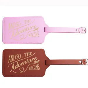Detailansicht von rosa und braunen PU-Leder-Gepäckanhängern mit goldenem Reisezitat-Druck.