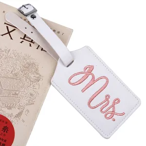 White PU leather luggage tag detail, pink embroidered Mrs text, travel suitcase accessory.