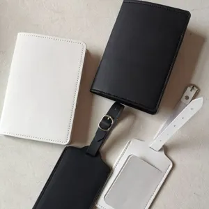 Detailed view of minimalist black and white PU leather passport cover and luggage tag set.
