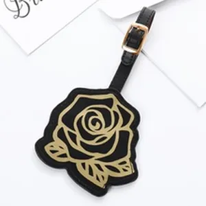 Etichetta per valigia in pelle nera con motivo rosa dorata, cinturino resistente per viaggi.